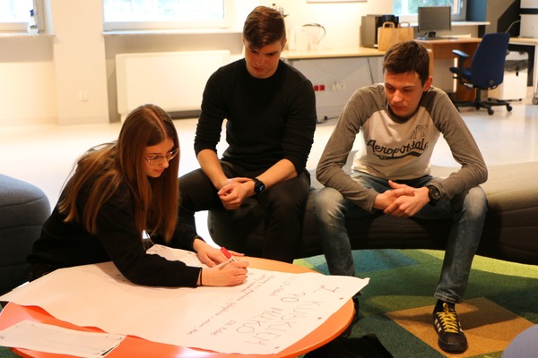 Młodzi ludzie pracujący nad przygotowaniem prezentacji swoich projektów biznesowych