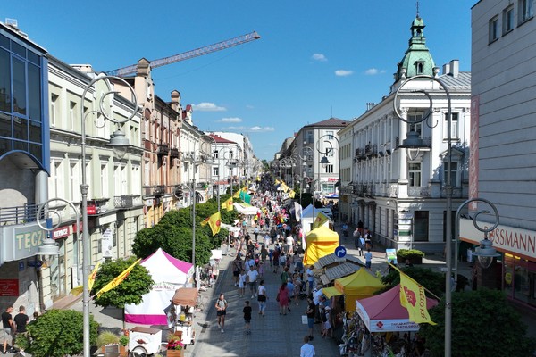 Ulica Sienkiewicza widziana z góry, na której ustawione są stoiska handlowe. Na ulicy jest wiele osób.