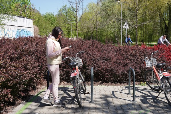 Kobieta przy rowerze miejskim na stacji w Dolinie Silnicy
