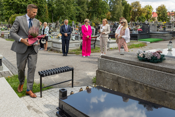 Kilka osób uczestniczących w złożeniu kwiatów na grobie Jerzego Pilcha