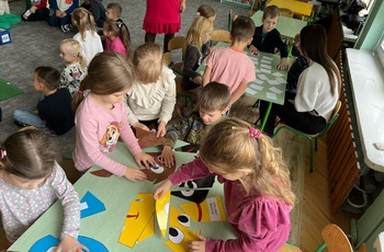 Dzieci układające ekologiczne puzzle przy stoliku