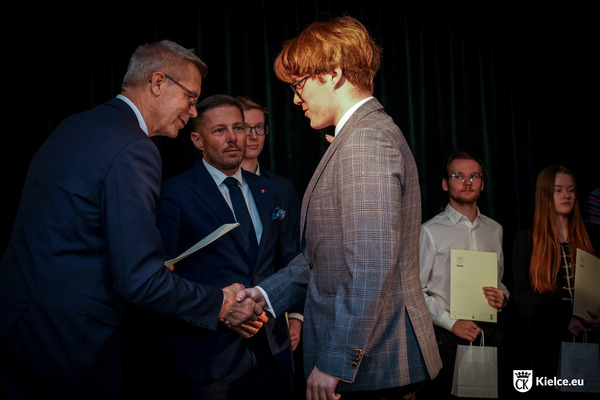 Prezydent Kielc Bogdan Wenta wręczający decyzję jednemu ze studentów, w tle wiceprezydent Marcin Chłodnicki oraz dwóch studentów