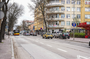 Ulica Paderewskiego. Kilka samochodów, autobus miejski i budynki.