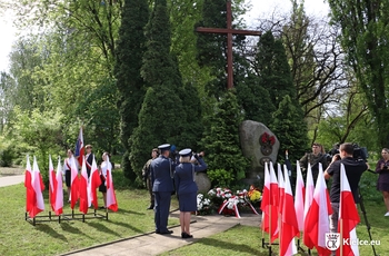 zdjęcie przedstawia pomnik Powstańców Listopadowych, obok niego flagi RP