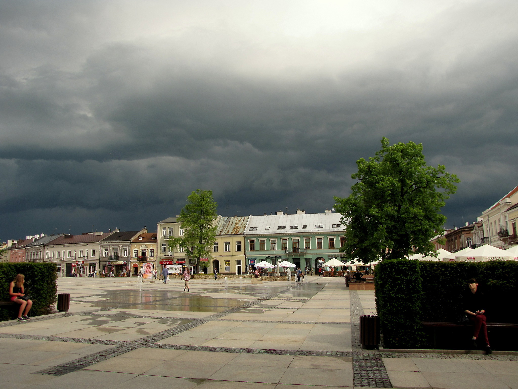 Zdjęcie przedstawiające Rynek w Kielcach. W tle chmury burzowe